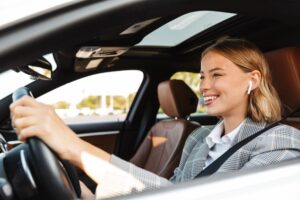 a woman wearing earbuds while driving