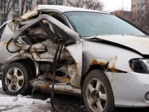 A white car with its side crunched in