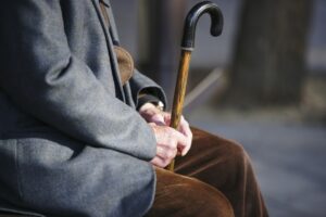 elderly man sitting with a cane
