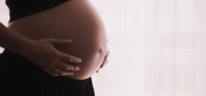 Photo of a pregnant woman touching her stomach