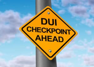 A sign in Florida that reads ‘DUI Checkpoint ahead’ against a cloudy blue sky.