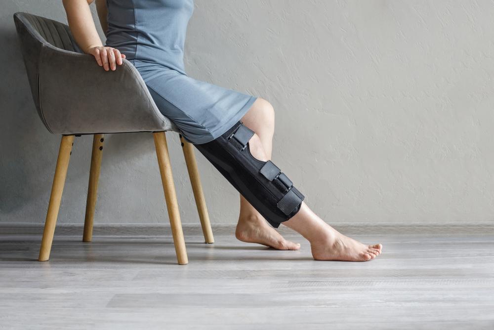 A woman, injured, gingerly seats herself in a room while she waits for a doctor assessment. She worries about Florida’s comparative negligence laws and who to turn to for help.