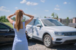 A woman looks at her damaged car and wonders what she can do if she is hit by an uninsured driver in Tampa.