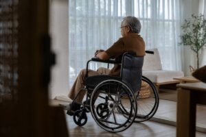 A lonely older man sits unattended in a wheelchair, illustrating how common nursing home abuse is in Florida.