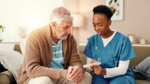 A nurse gives medication to a nursing home resident while checking the prescribed pills. Carefully giving the right medication helps protect nursing home residents from preventable medication errors.