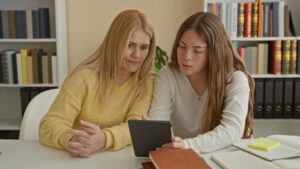 image of a mother and daughter figuring out paperwork on a desk for an article that goes over what damages a family can claim after a fatal car accident.