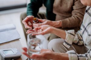 Someone giving a senior medication to take. Find out what to do if a nursing home medication error injured your loved one.